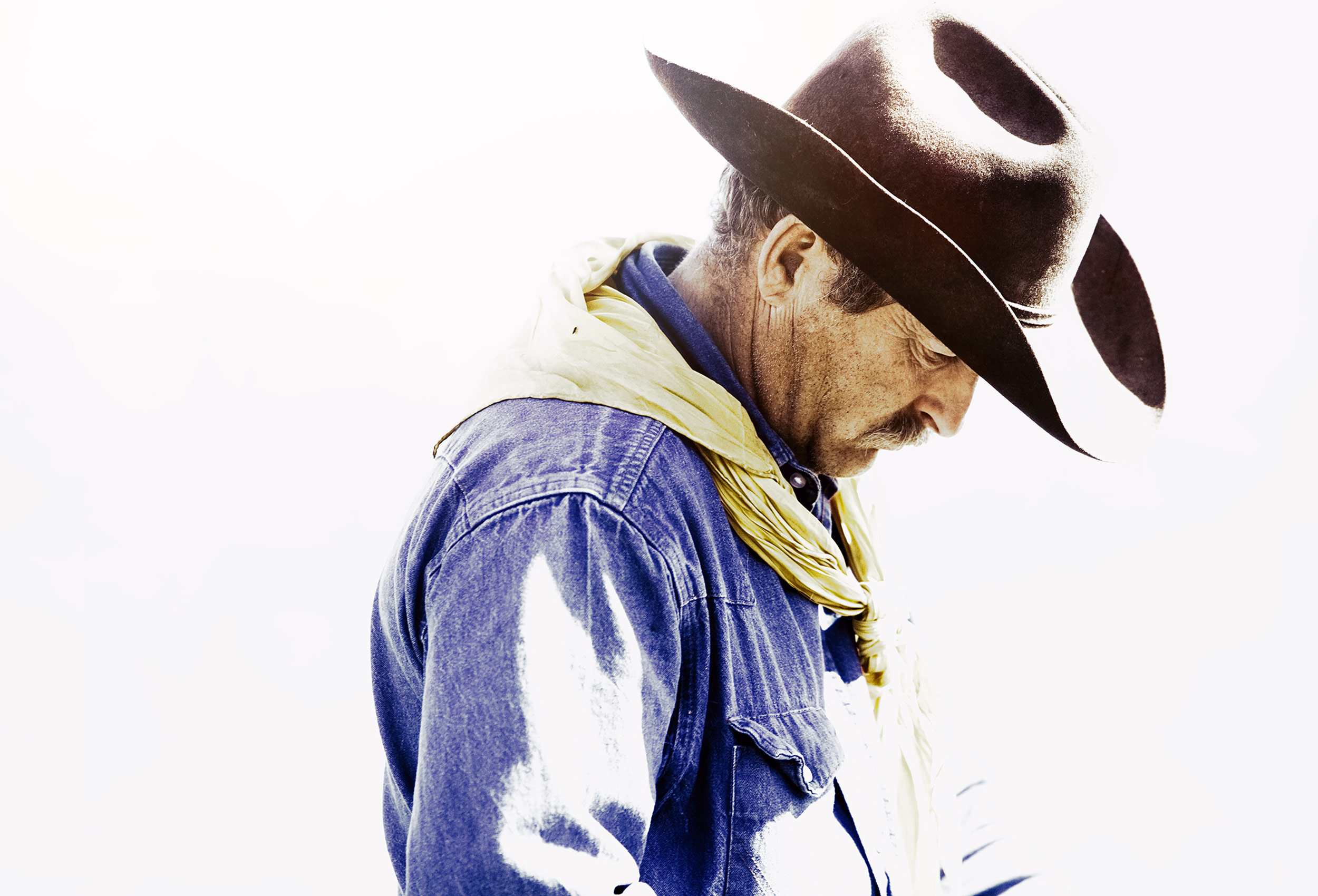 Cowboy looking down against a white background