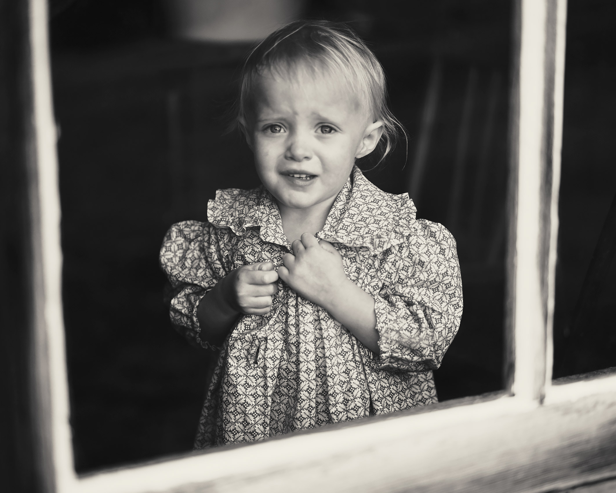 Through a window of a little girl with tears