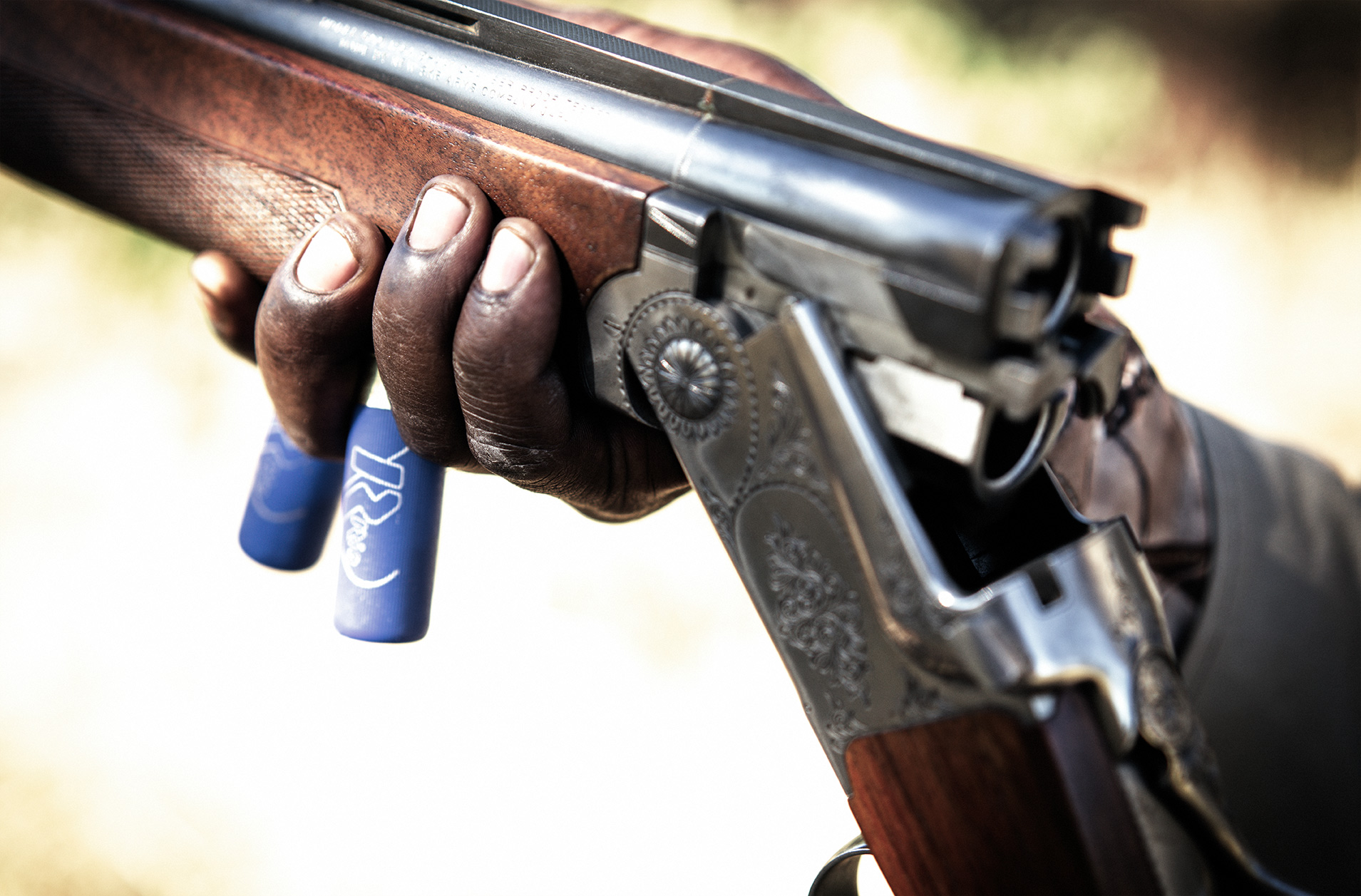 The hands of a hunter holding a shotgun in Namibia, Africa