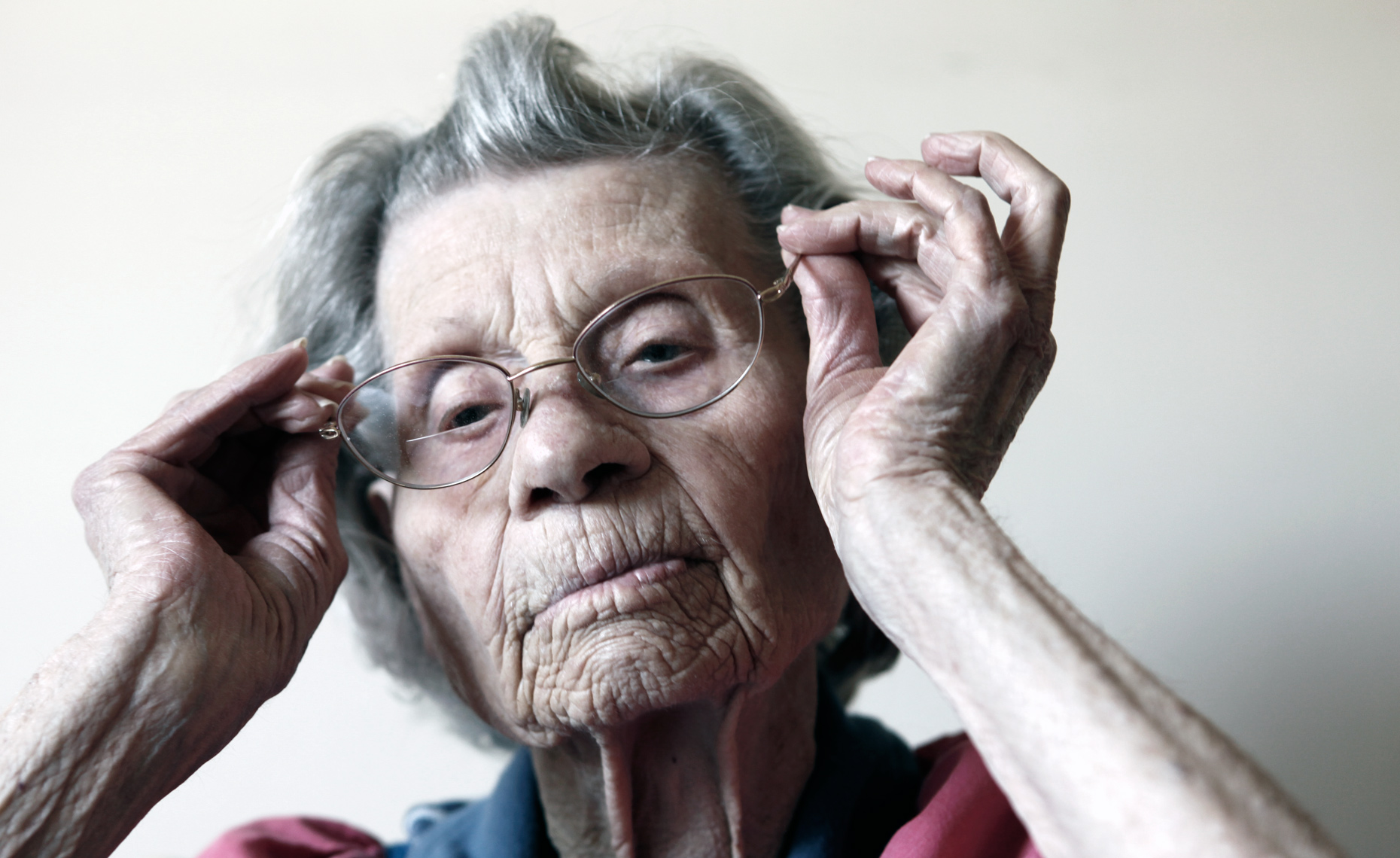 Elderly woman adjusting her glasses - AARP